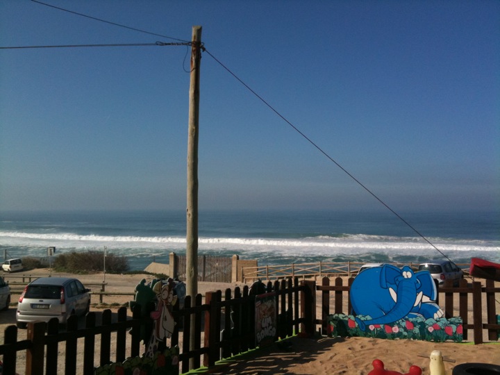 Vista da sala de jantar para o parque infantil e para o mar.